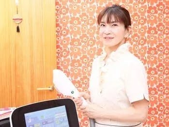 施術で使用する最新の脱毛マシンを持つオーナー