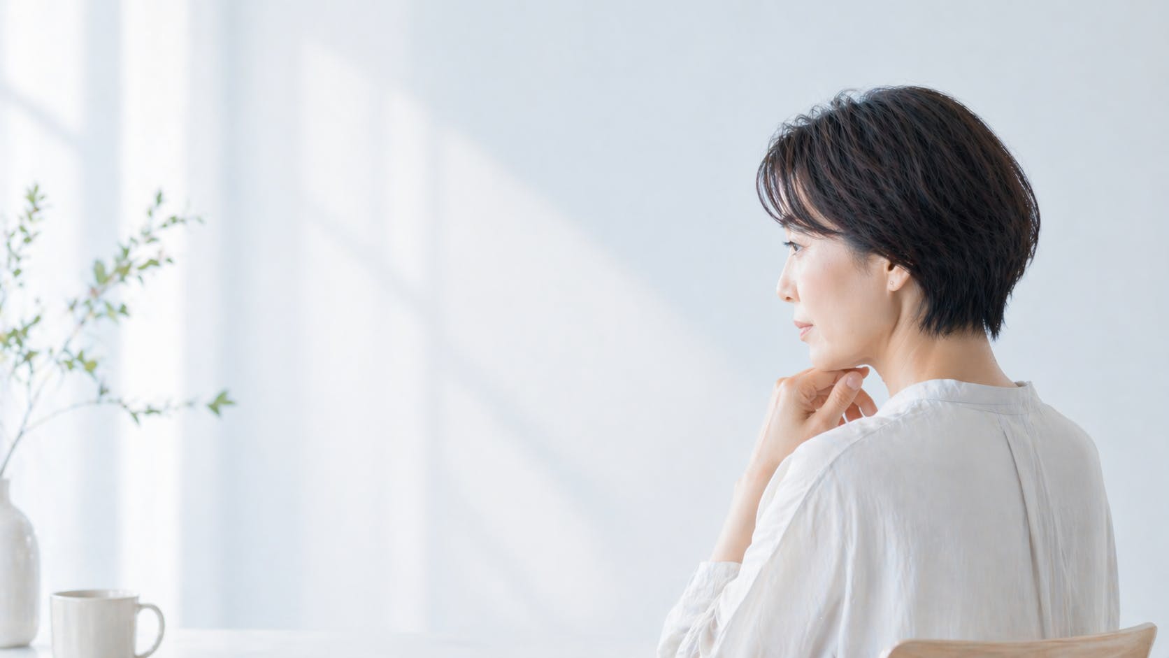 考え事をしている40代女性、