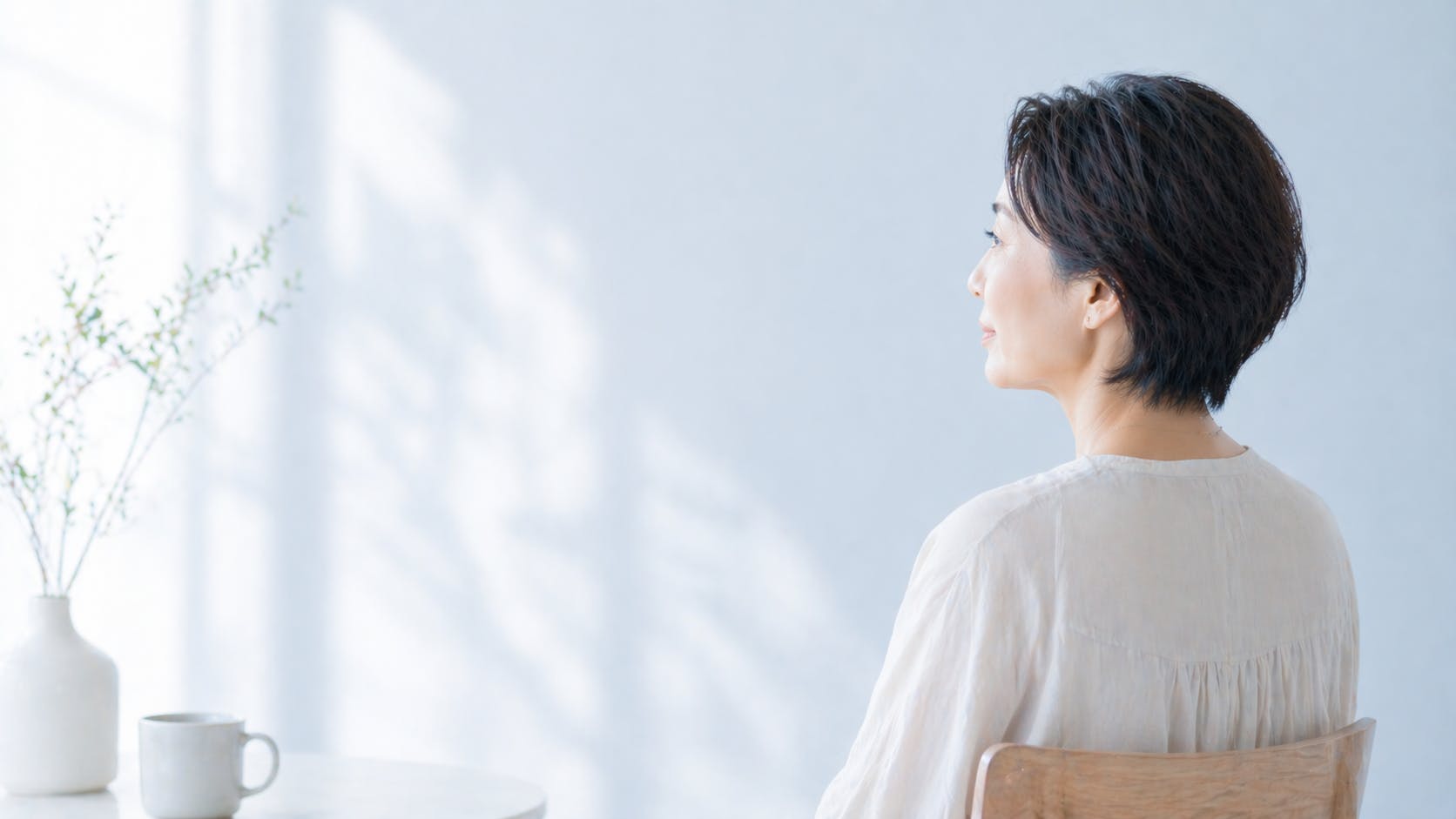 少し安心して、行動しようとしている50代女性、穏やかな日差し、