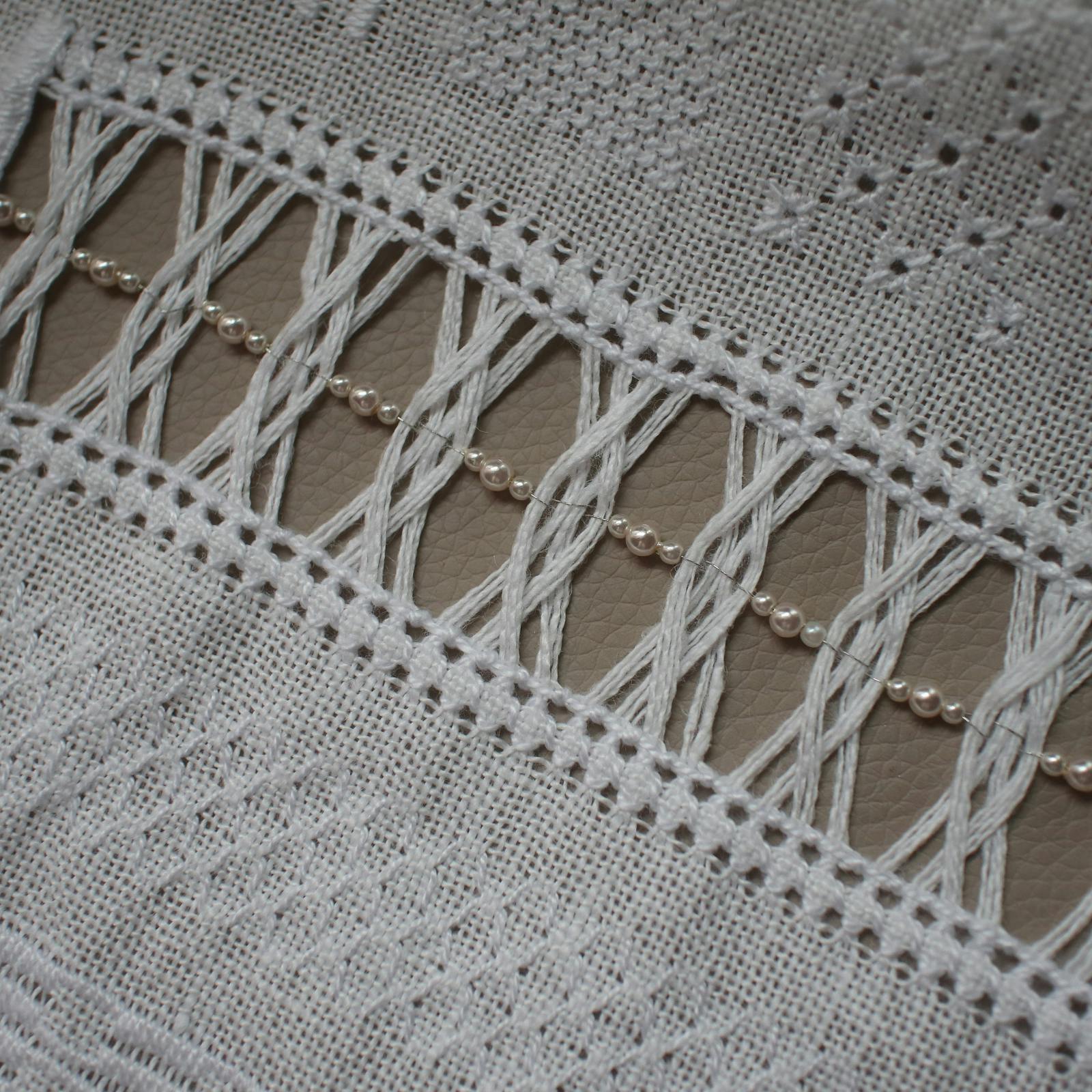 ドロンワークの透かし模様に小粒のパールを等間隔に通した、華やかな白糸刺繍のアレン